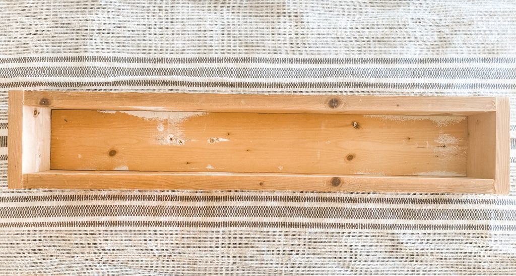empty wood rectangle centerpiece made from from 1x4s on top of table runner