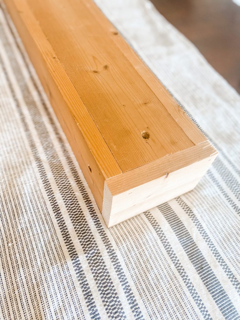 bottom of wood planter box on black and white table runner