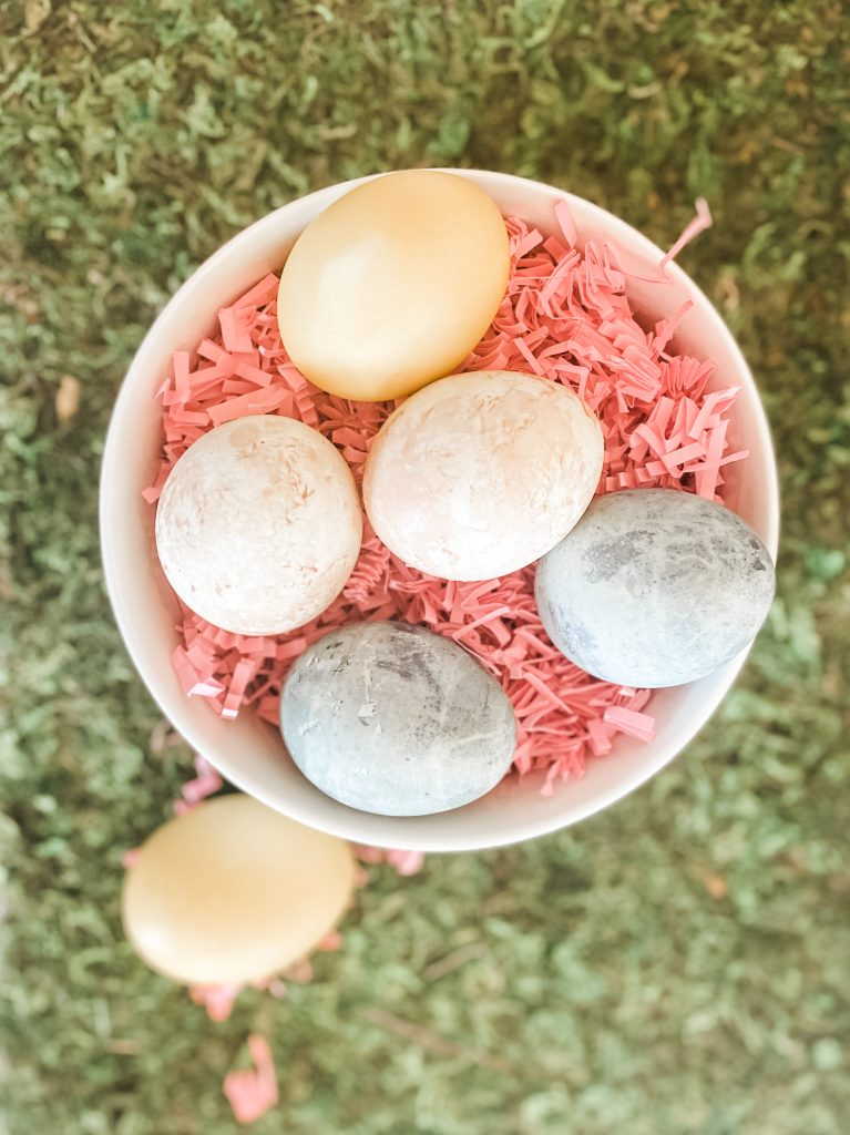 eggs dyed with naturally ingredients in bowl with pink confetti sitting on grass
