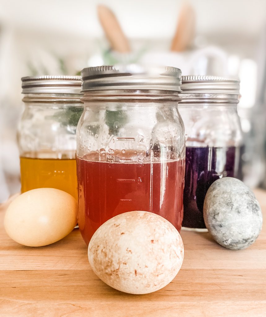 eggs dyed with natural ingredients shown with liquid colors in mason jars