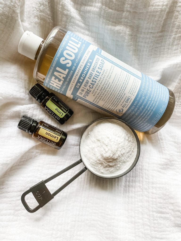 baking soda in measuring cup Castile Soap and lime and lemon essential oils shown for ingredients