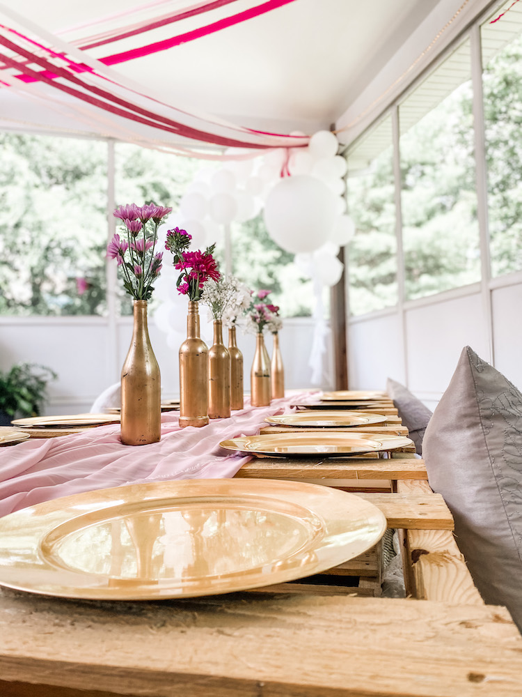 close up of a table set with airy and pink decor in background