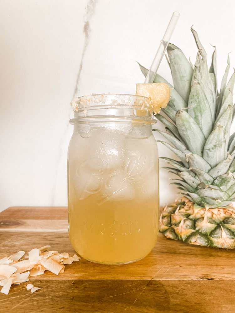 drink with ice coconut crisps and pineapple top on the side