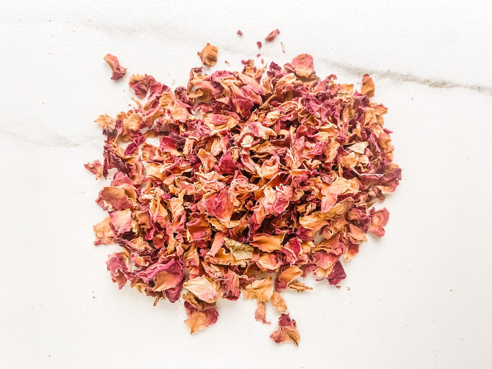 pile of dried roses on white marble surface