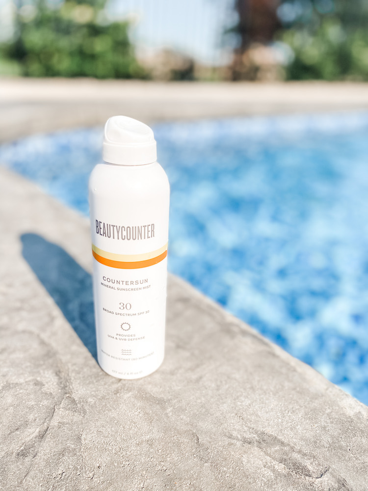 Beautycounter sunscreen sitting by a pool