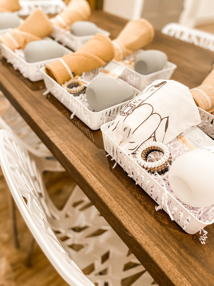 Bachelorette Party gift boxes with hair bands, and bride shirt, cups, and hats on a wooden table