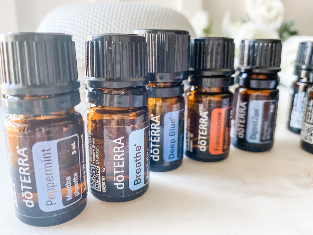 close up of a variety of essential oils sitting on a marble surface