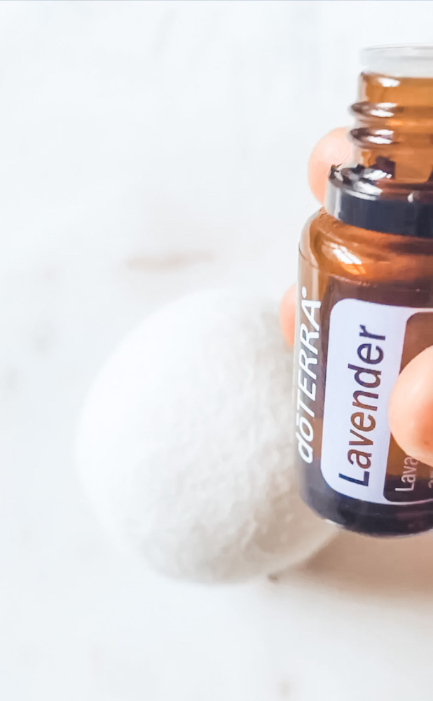 Lavender essential oil with wool dryer ball and white background